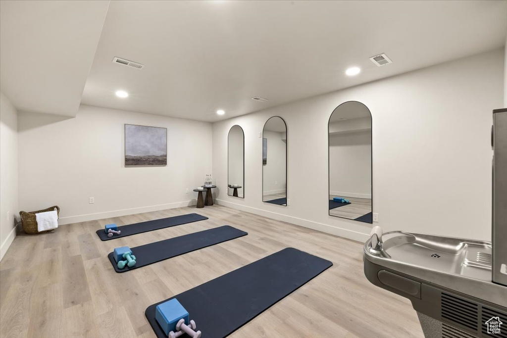 Exercise room with recessed lighting, wood finished floors, and baseboards