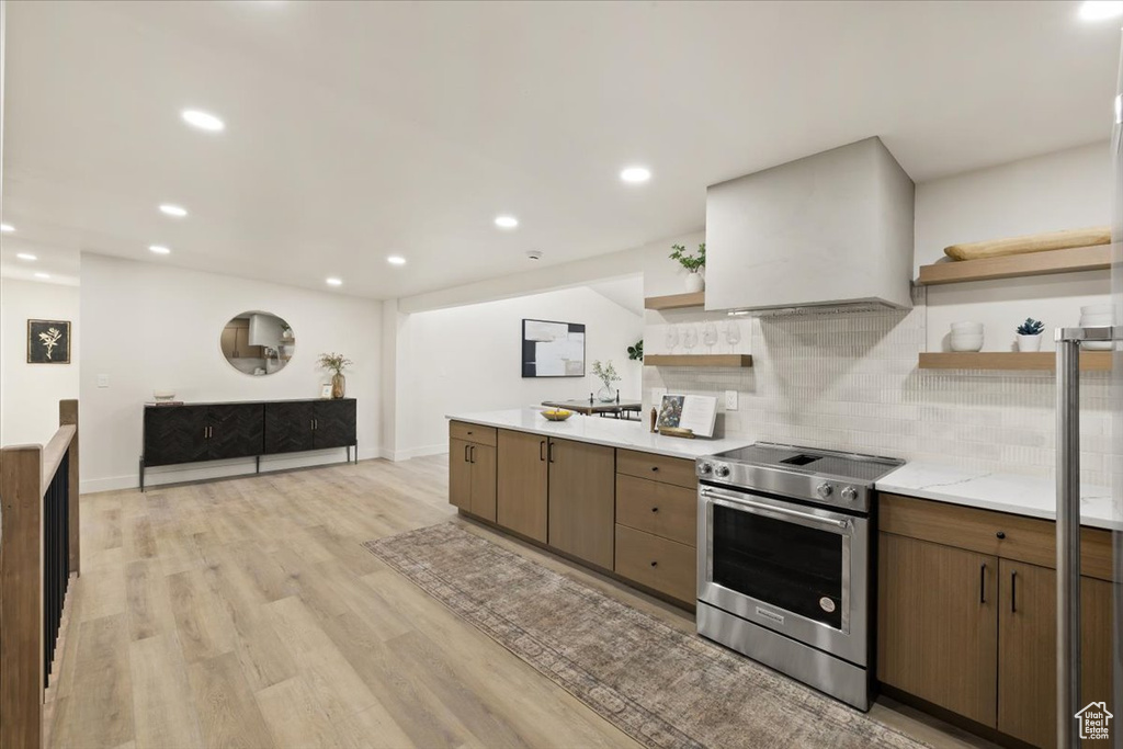 Kitchen featuring open shelves, electric stove, tasteful backsplash, light countertops, and recessed lighting