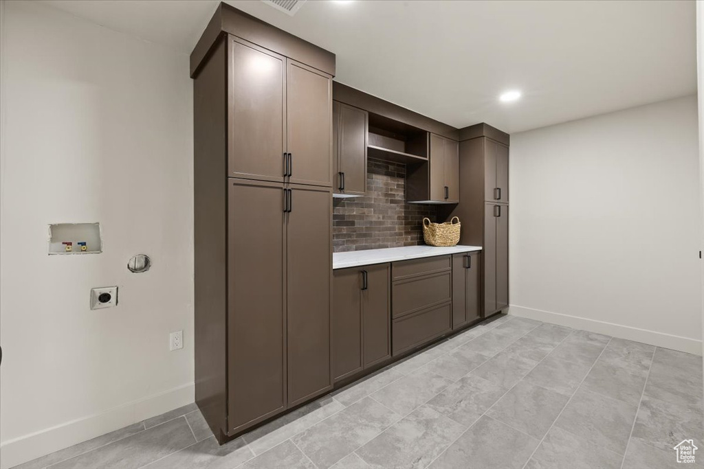 Washroom featuring hookup for an electric dryer, cabinet space, washer hookup, baseboards, and recessed lighting