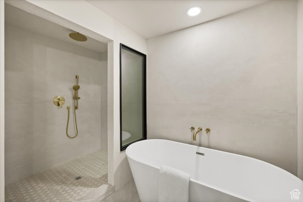 Bathroom with a tile shower, a soaking tub, and recessed lighting