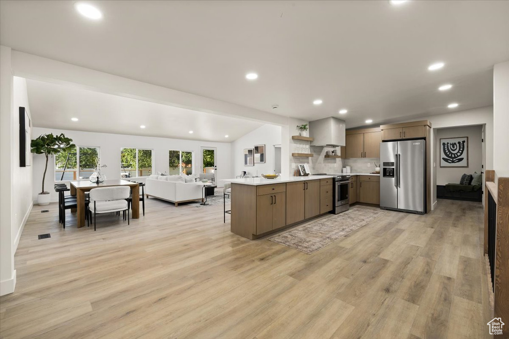 Kitchen with stainless steel appliances, open floor plan, open shelves, recessed lighting, and light countertops
