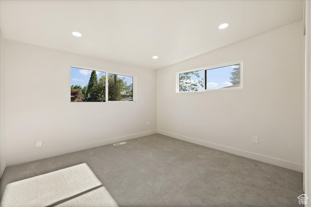 Spare room with baseboards, light colored carpet, and recessed lighting