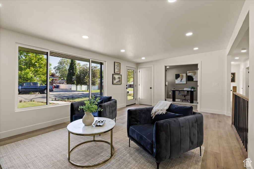 Living room featuring light wood-style floors, healthy amount of natural light, recessed lighting, and baseboards