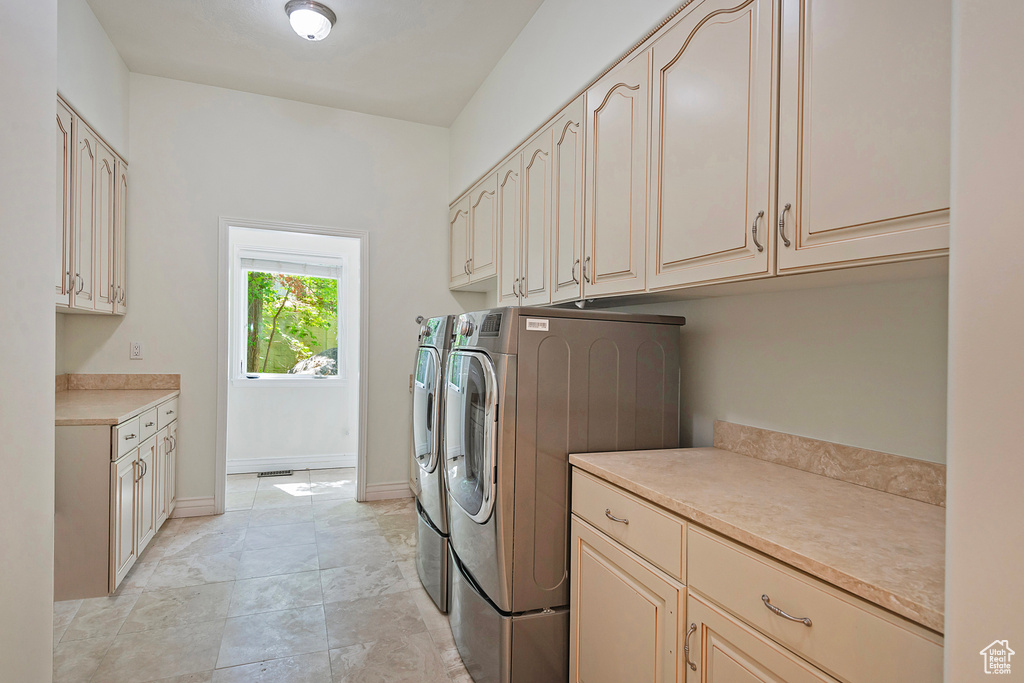 Laundry room with cabinet space, independent washer and dryer, and baseboards