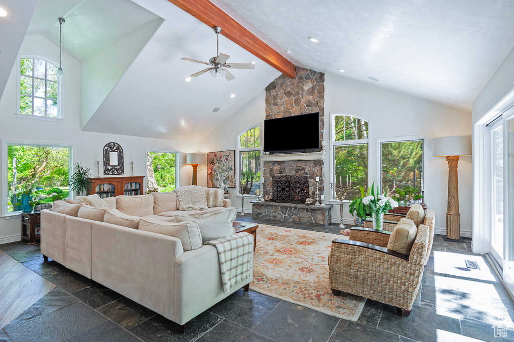 Living room with a fireplace, high vaulted ceiling, beam ceiling, ceiling fan, and recessed lighting
