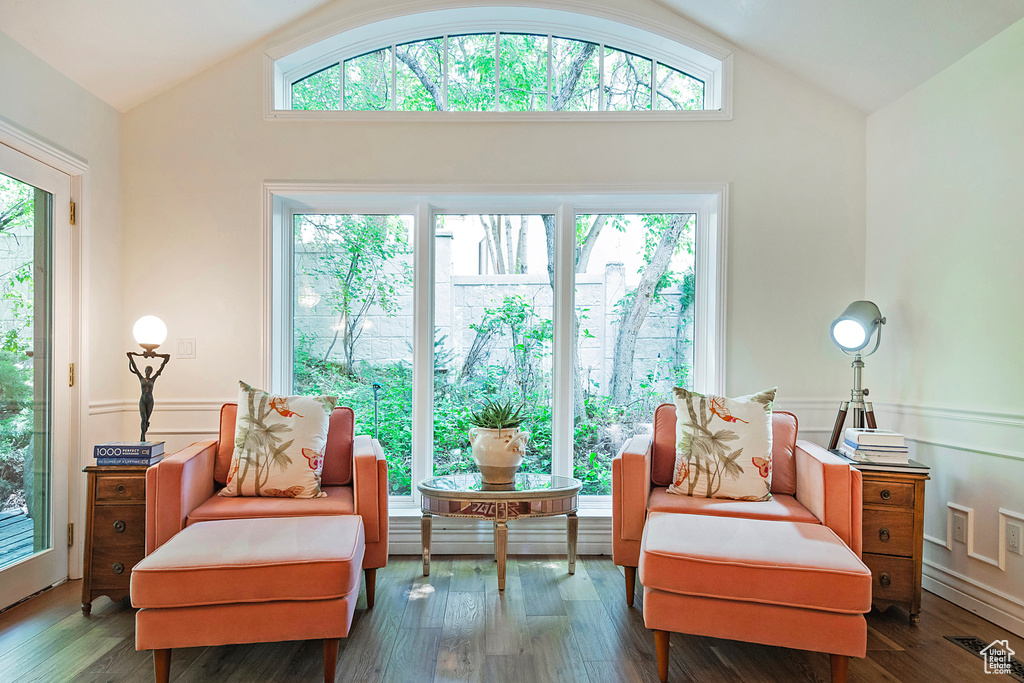 Sitting room featuring lofted ceiling, wood finished floors, and a wainscoted wall