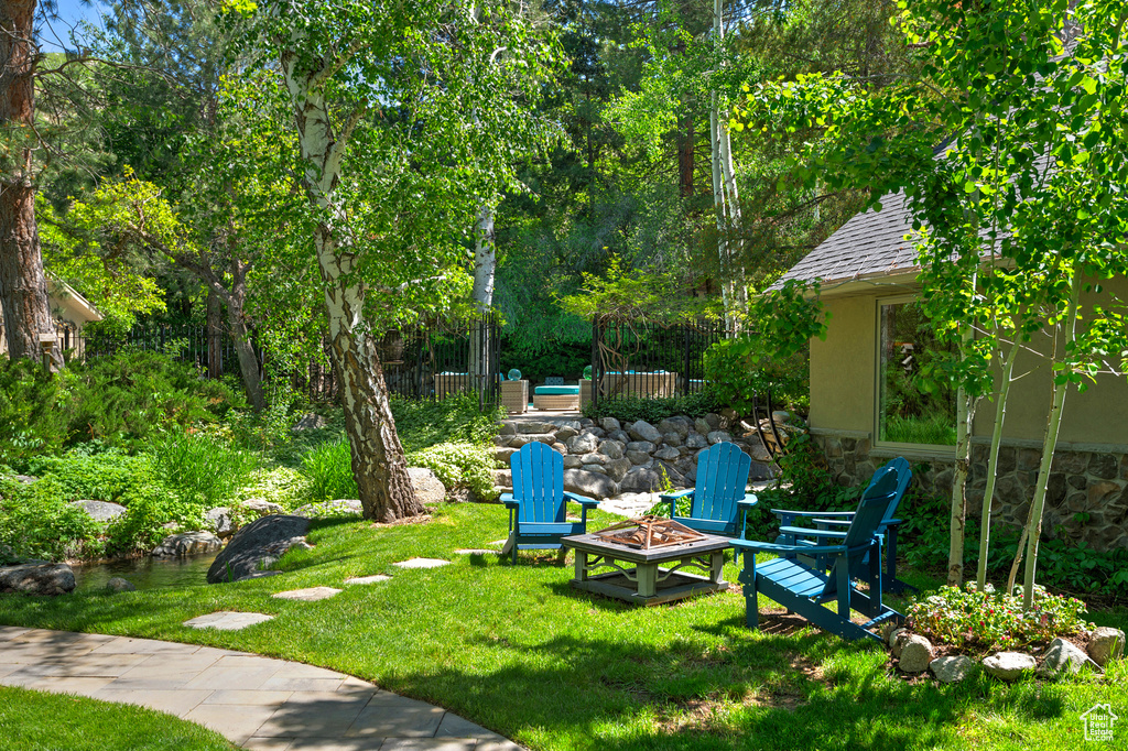 View of grassy yard featuring an outdoor fire pit