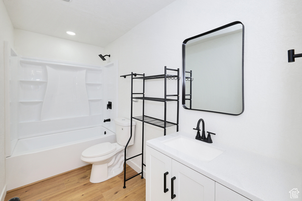 Full bath featuring vanity, toilet, wood finished floors, and bathing tub / shower combination