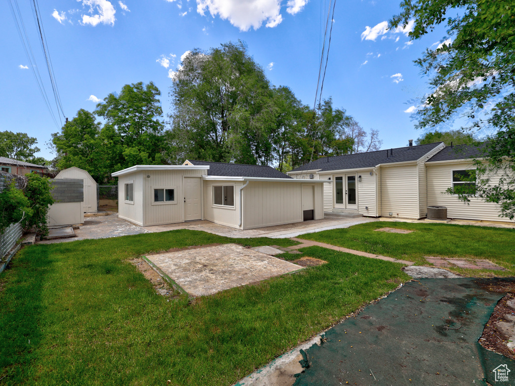 Back of house featuring a patio, a yard, and cooling unit