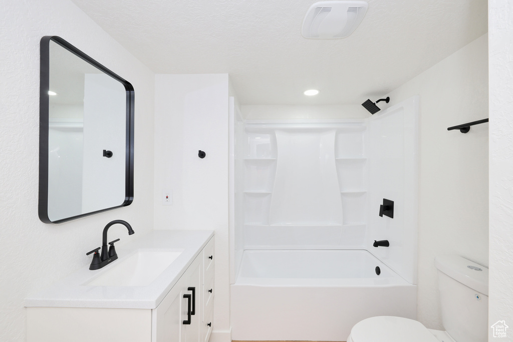 Full bathroom with vanity, toilet, shower / washtub combination, and recessed lighting