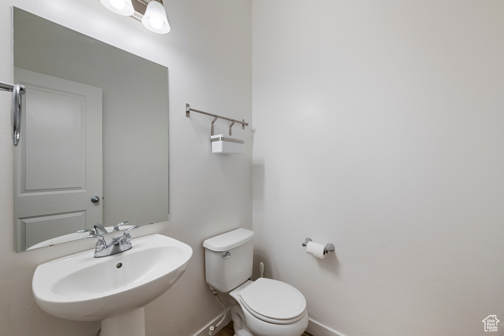 Bathroom featuring a sink, baseboards, and toilet