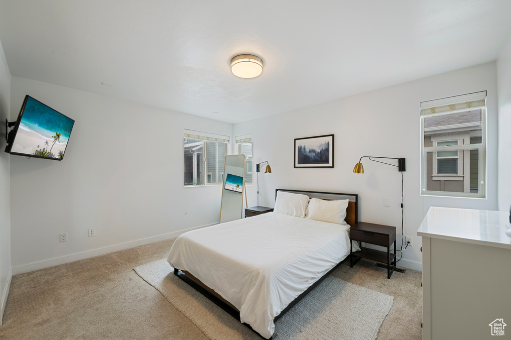 Bedroom featuring light colored carpet and baseboards