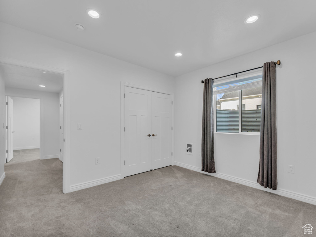 Unfurnished bedroom featuring carpet flooring, recessed lighting, baseboards, and a closet