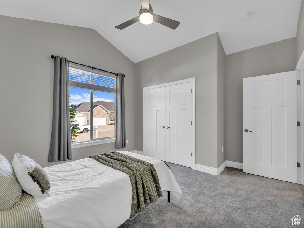 Bedroom featuring carpet floors, lofted ceiling, ceiling fan, a closet, and baseboards
