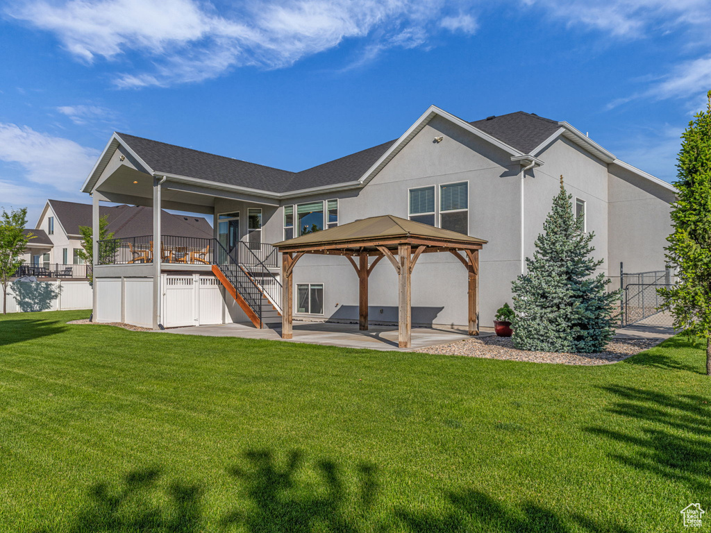 Back of property featuring stairway, a patio area, a gazebo, stucco siding, and a deck