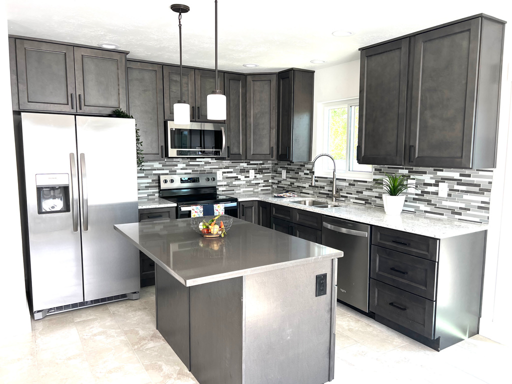 Kitchen featuring stainless steel appliances, a sink, backsplash, pendant lighting, and a center island