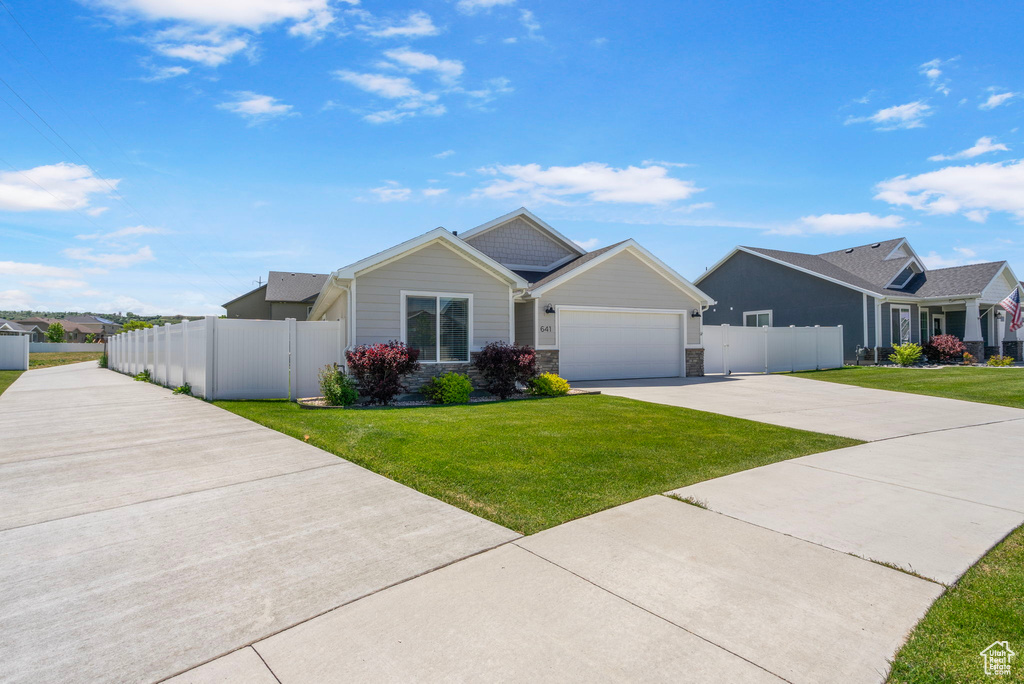 View of front of house with concrete driveway, a garage, and stone siding