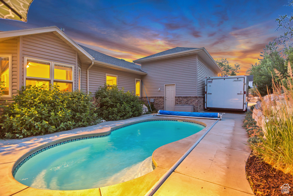 Pool at dusk with a patio