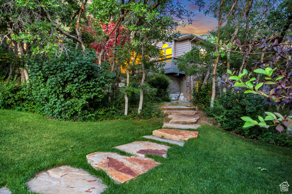 View of grassy yard with a balcony