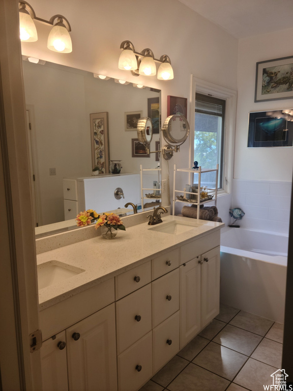 Bathroom featuring double vanity, tile patterned floors, and a garden tub