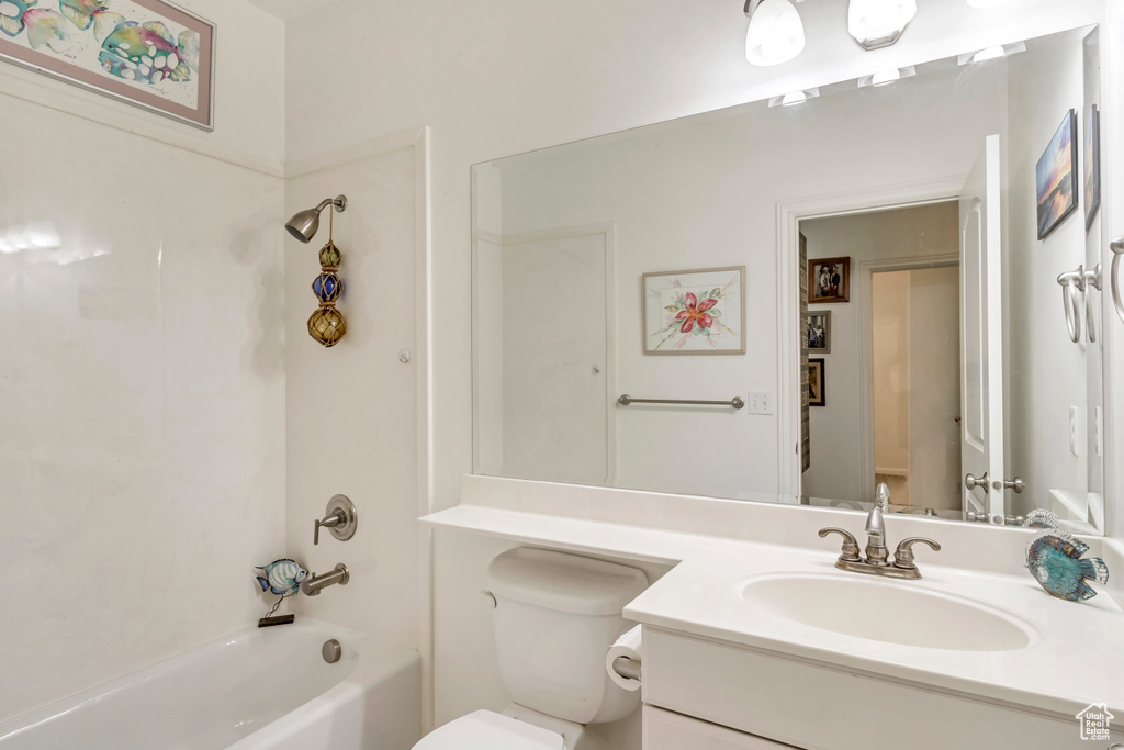 Bathroom featuring vanity,  shower combination, and toilet