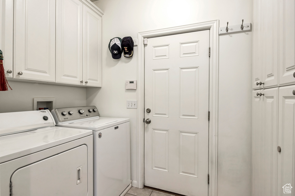 Laundry area featuring cabinet space and separate washer and dryer