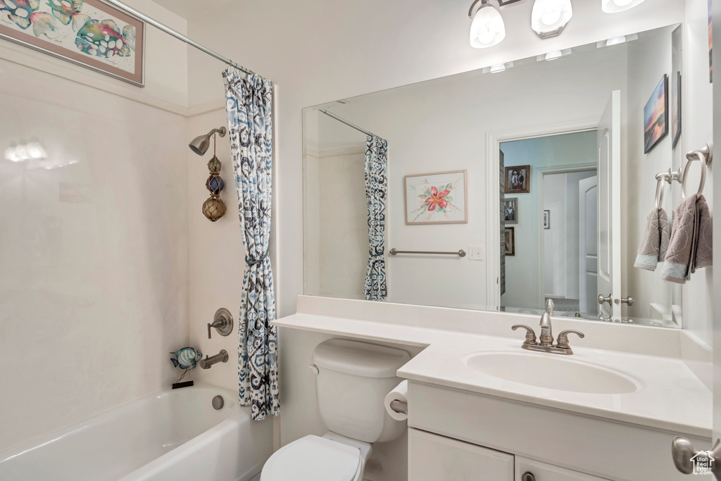 Full bathroom with vanity, shower / tub combo with curtain, and toilet
