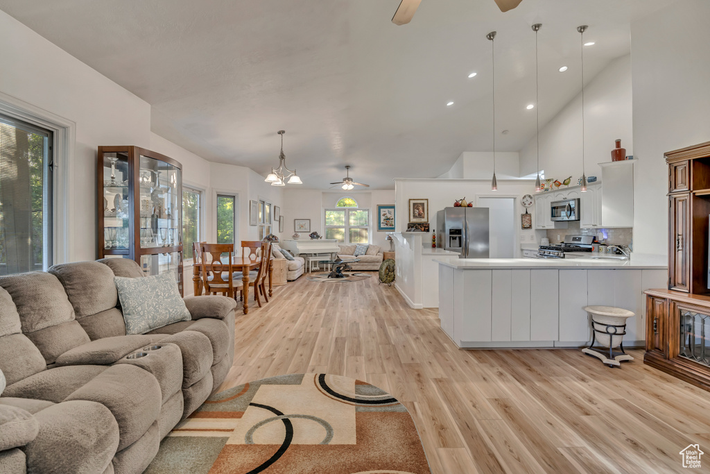 Living area featuring a ceiling fan, light wood-type flooring, and recessed lighting