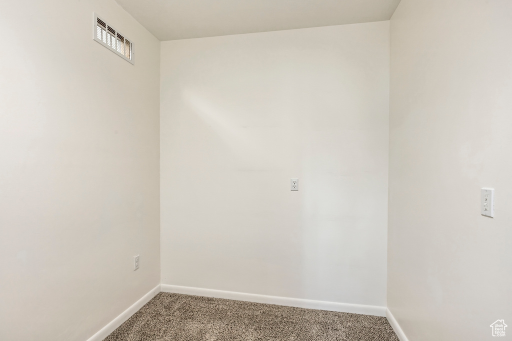 Carpeted empty room featuring baseboards