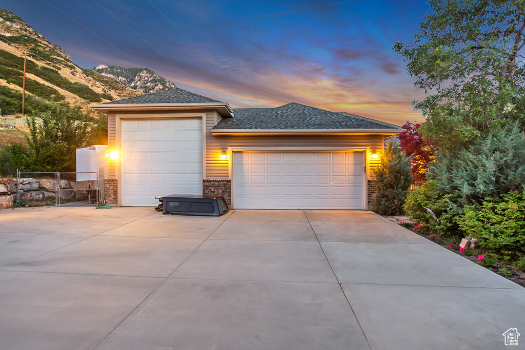 View of front facade featuring brick siding, a gate, a mountain view, and a garage