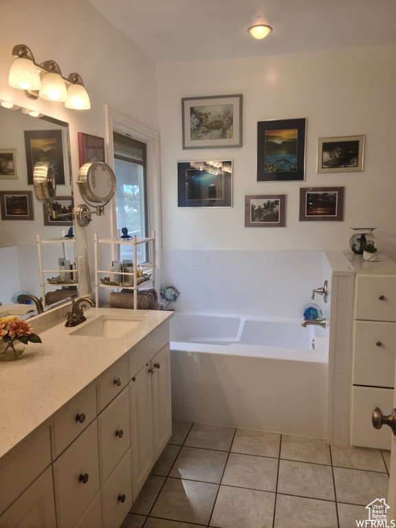 Full bath featuring vanity, a garden tub, and tile patterned flooring