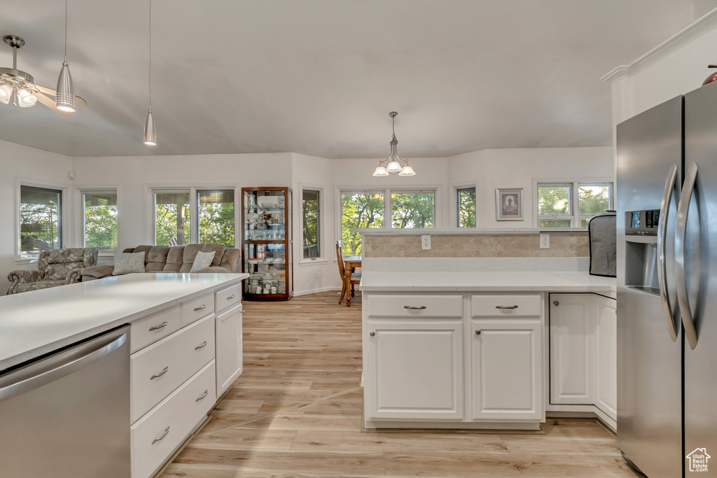 Kitchen with appliances with stainless steel finishes, light countertops, and plenty of natural light