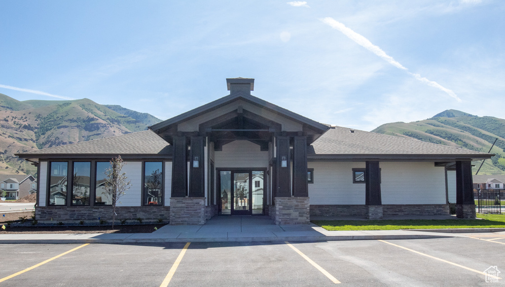 View of building exterior with a mountain view and uncovered parking