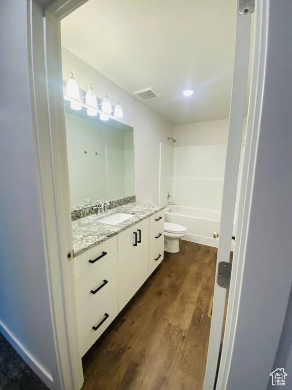 Full bathroom featuring vanity, toilet, wood finished floors, and bathtub / shower combination