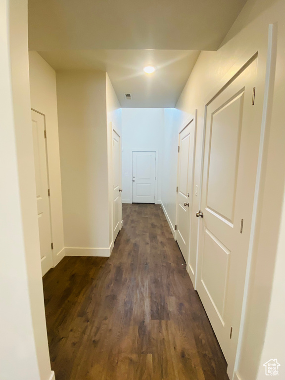 Hallway featuring dark wood finished floors and baseboards