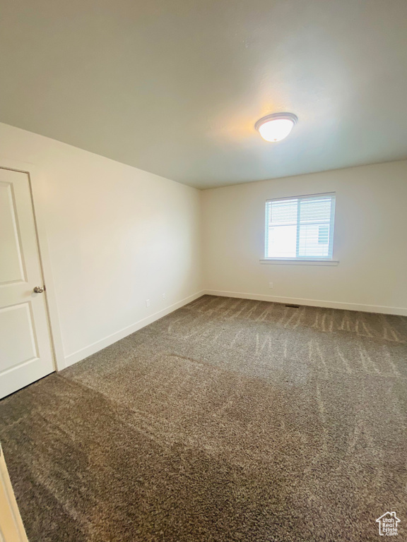 Spare room featuring baseboards and carpet flooring