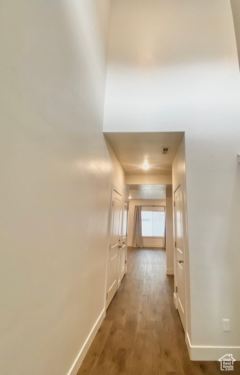 Hall with baseboards and wood finished floors