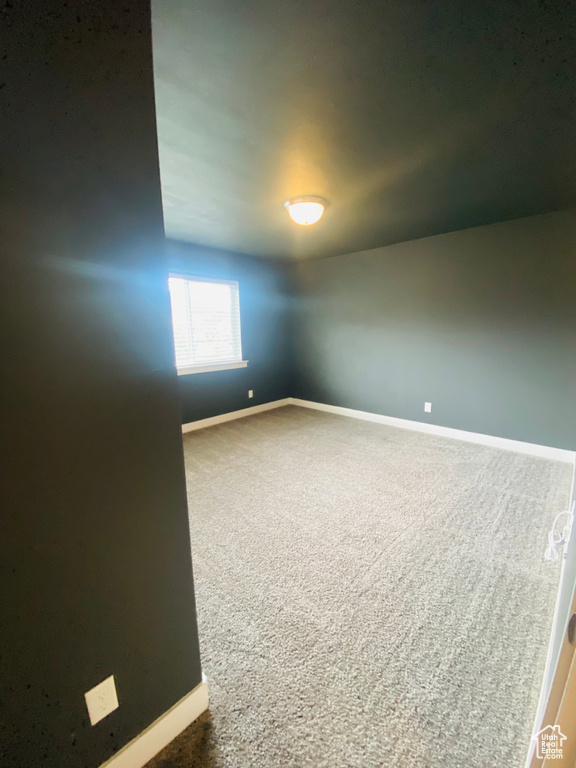 Spare room with baseboards and carpet floors