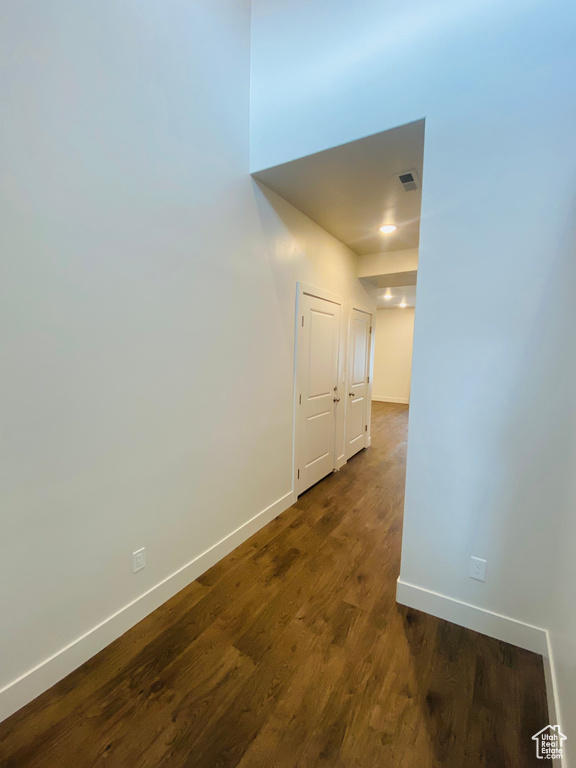 Hall with baseboards and dark wood-style flooring