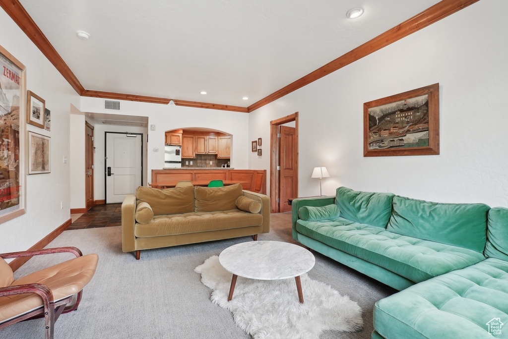 Living area featuring crown molding, recessed lighting, baseboards, and light carpet