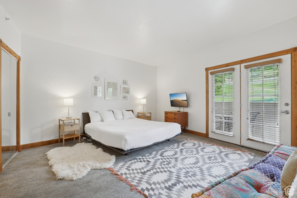 Carpeted bedroom with access to outside and baseboards