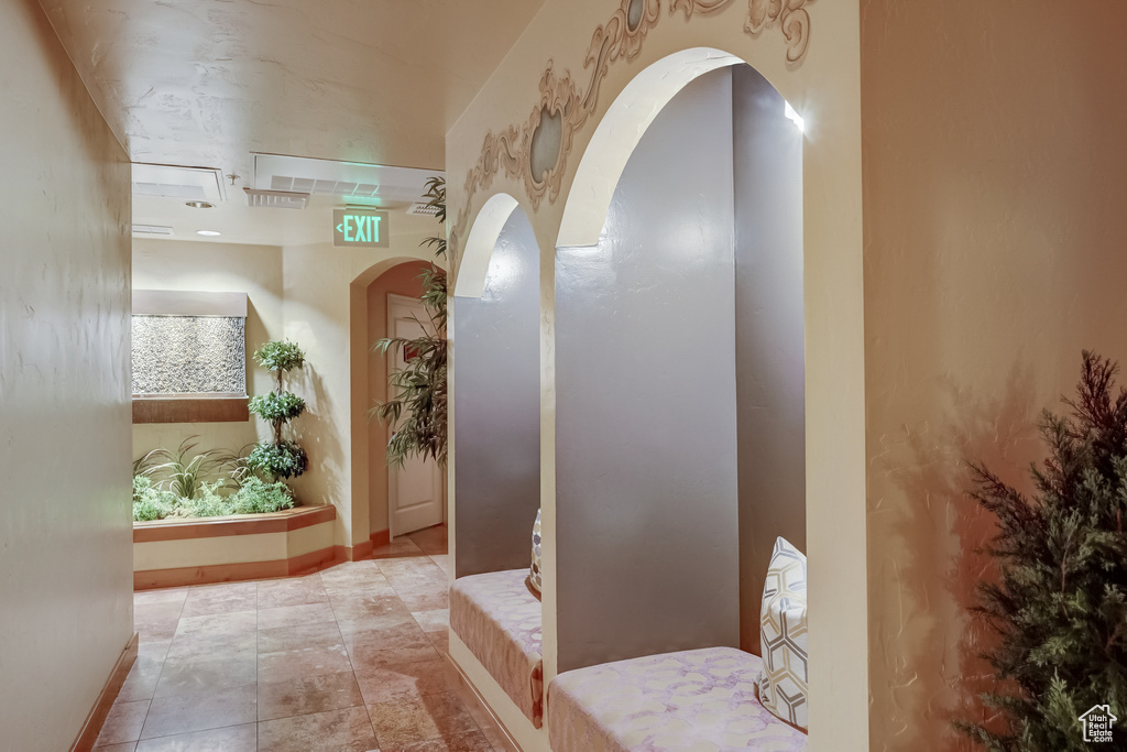 Corridor featuring baseboards and arched walkways