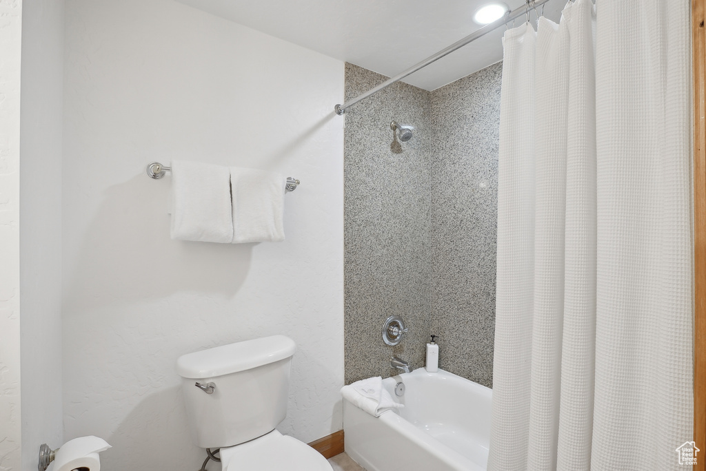 Bathroom with shower / bath combo with shower curtain and toilet