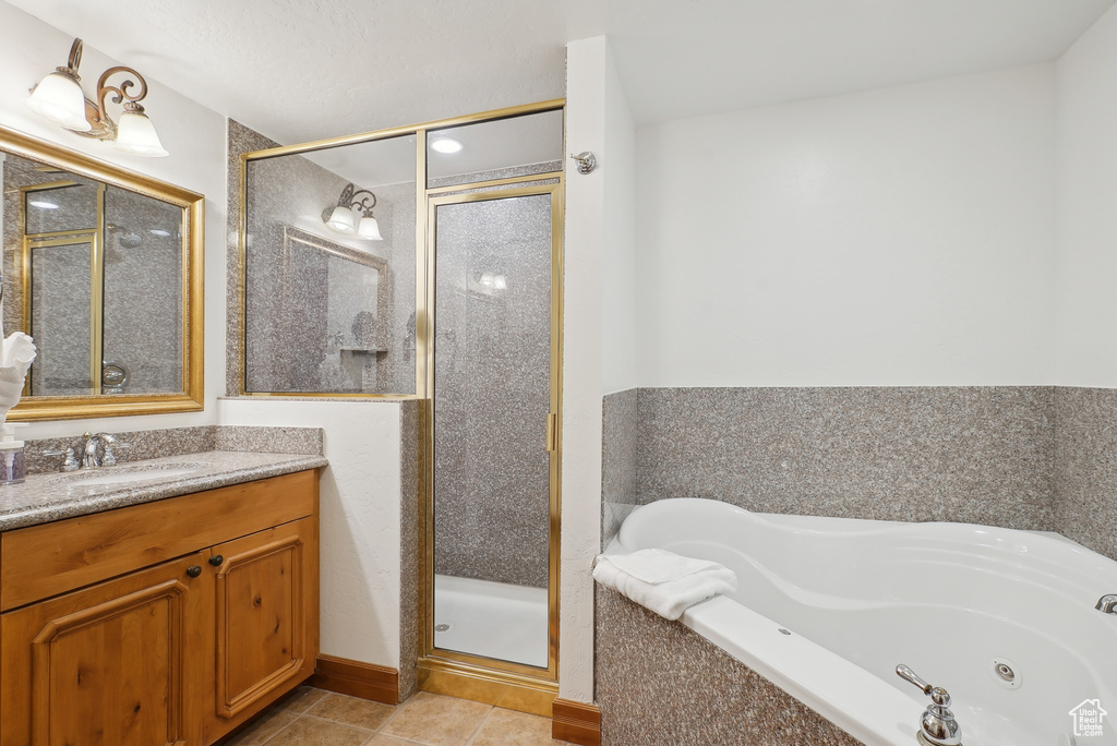 Full bath featuring a stall shower, tile patterned flooring, a tub with jets, and vanity