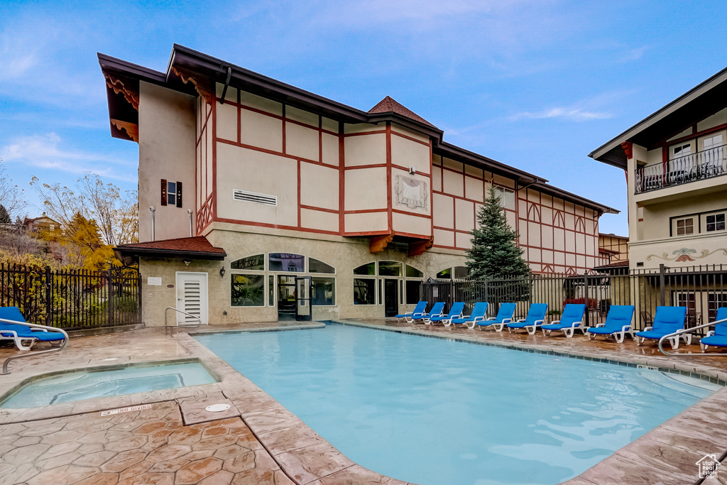 Community pool with a hot tub and a patio