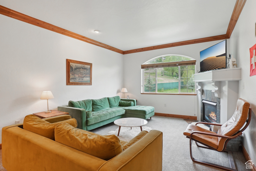 Carpeted living area featuring a tiled fireplace and baseboards