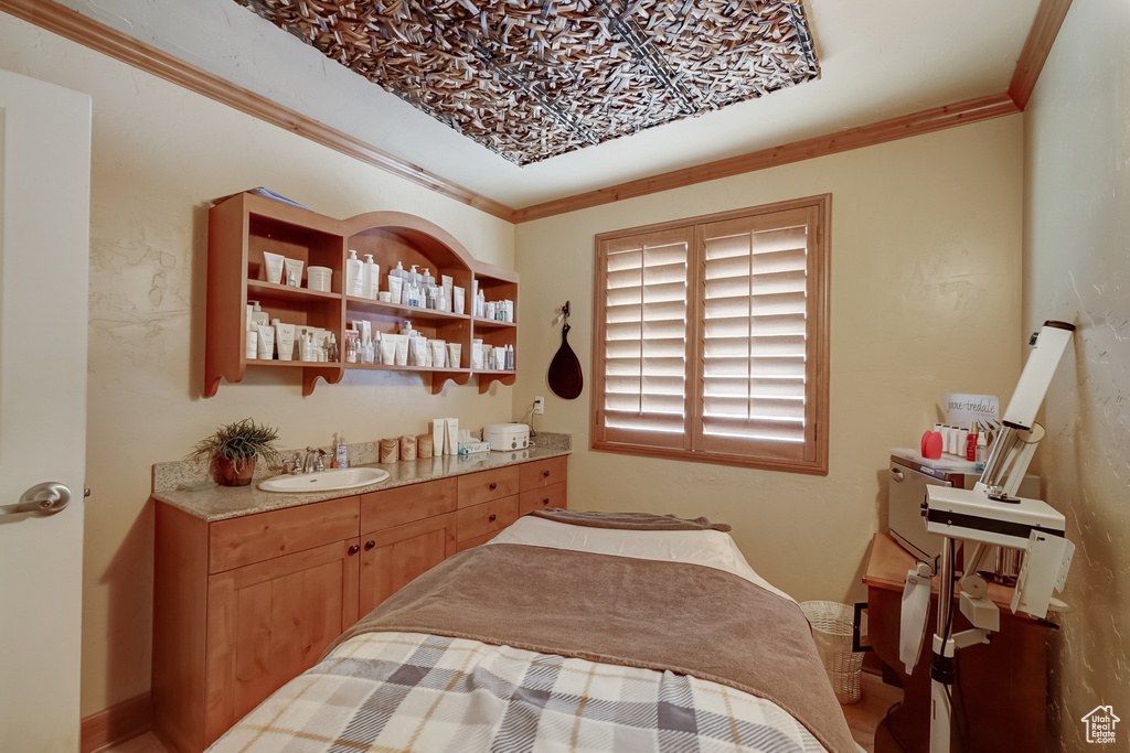 Bedroom featuring a sink and crown molding