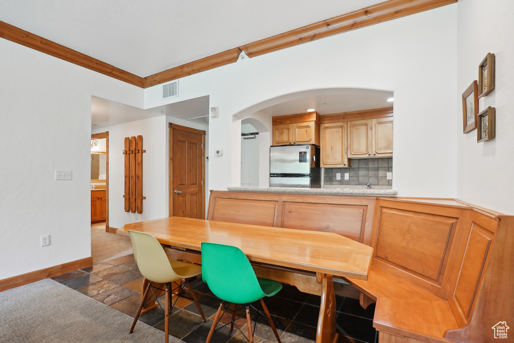 Dining room with baseboards, arched walkways, and stone tile floors