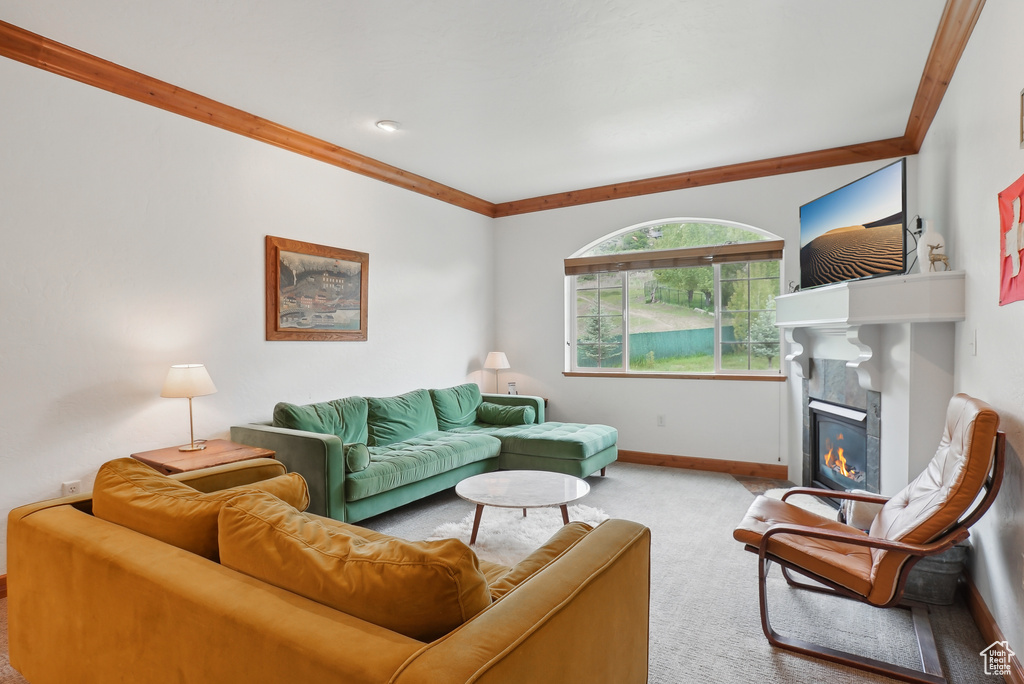 Carpeted living area featuring a tiled fireplace and baseboards