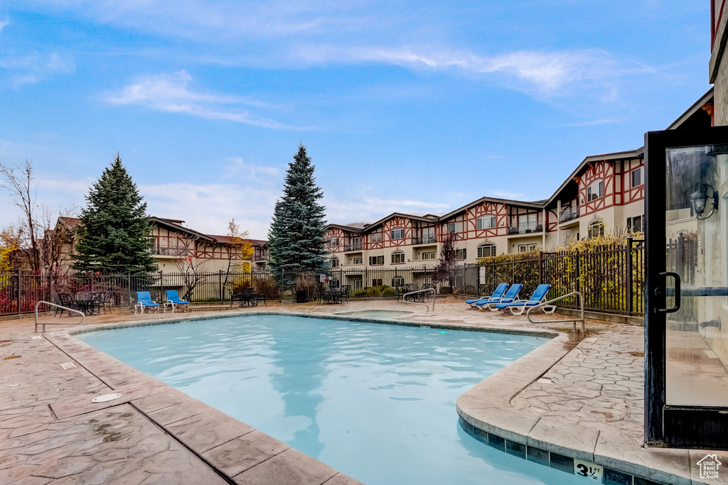 Community pool featuring a patio and a residential view